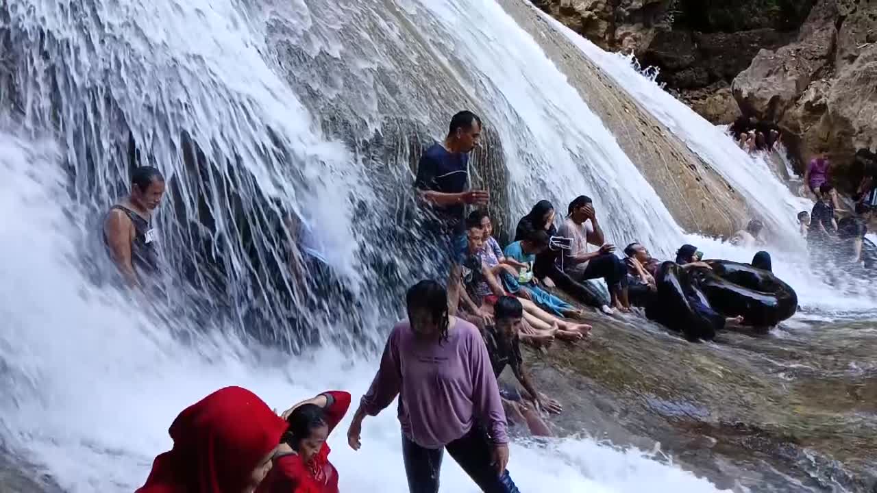 People enjoying a refreshing day at a beautiful waterfall
