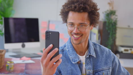 Hombre-Que-Dirige-Un-Negocio-En-Línea-Haciendo-Velas-Boutique-En-Casa-Con-Videollamada-Por-Teléfono-Móvil