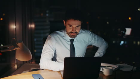 successful businessman working late evening in modern office alone close up.