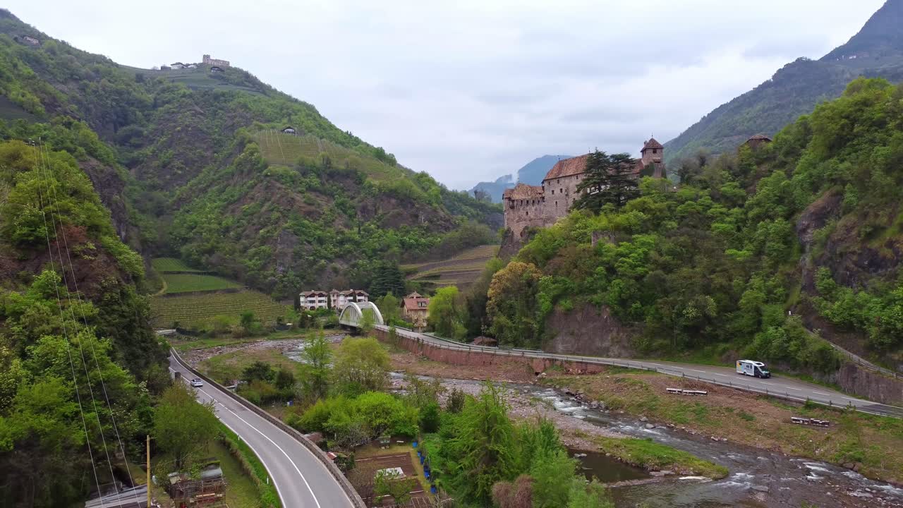 Flying out from Roncolo Castle near city of Bolzano in South Tyrol in Italy, wide shot drone footage