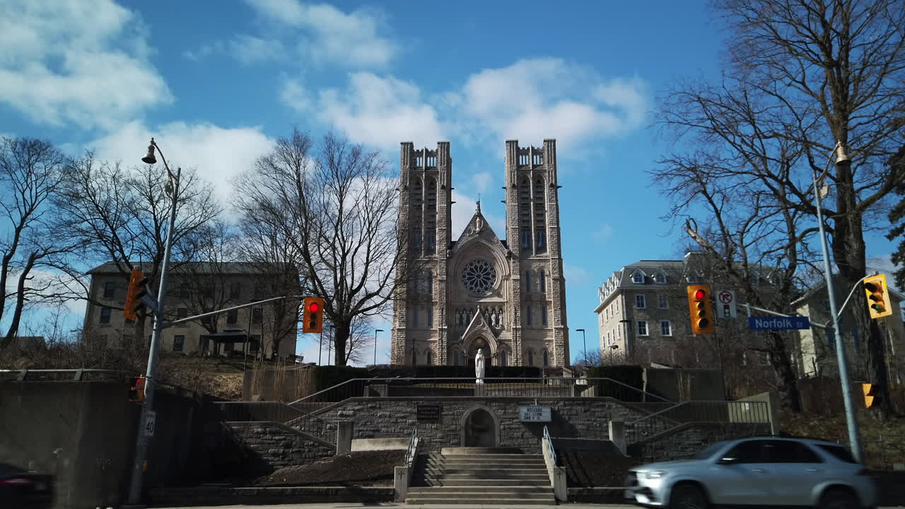 Wide exterior view of Basilica of Our Lady Immaculate in Guelph, seen in the distance from downtown