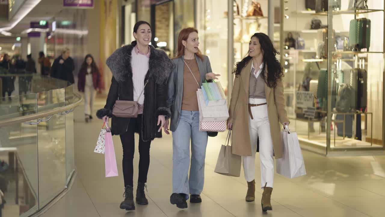 Three friends enjoy a shopping trip in a modern mall