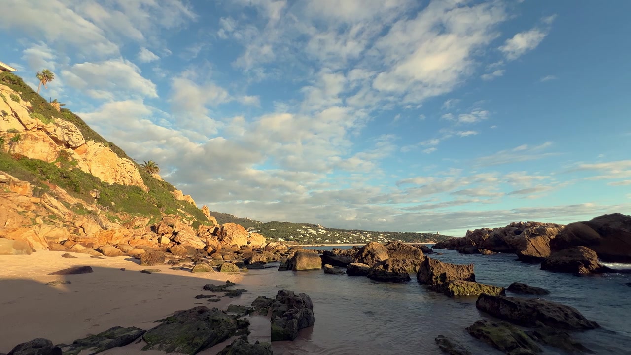 Vista cênica de uma bela praia com rochas e falésias ao nascer do sol, criando uma paisagem costeira pacífica e idílica em Barbate, Espanha.