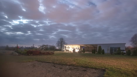 casa moderna acogedora en el paisaje rural, paisaje de nubes que fluye por encima, lapso de tiempo