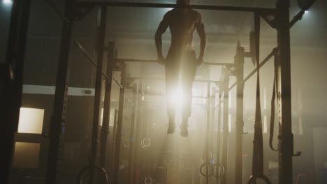 hombre realizando pull-ups en un gimnasio