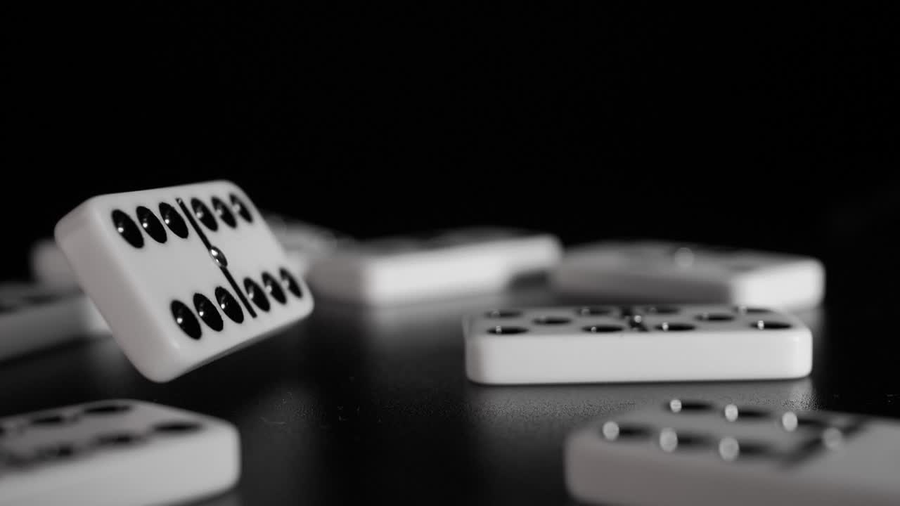 White domino dice fall on a black background