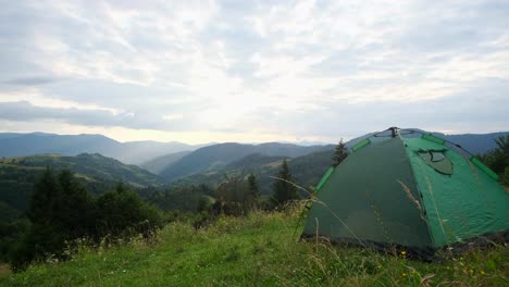 couple collaborates to set up tent for camping in forest man and woman work together to assemble camping tent in lush forest as one lifts flexible pole and other secures fabric on grassy ground surrounded by tall trees