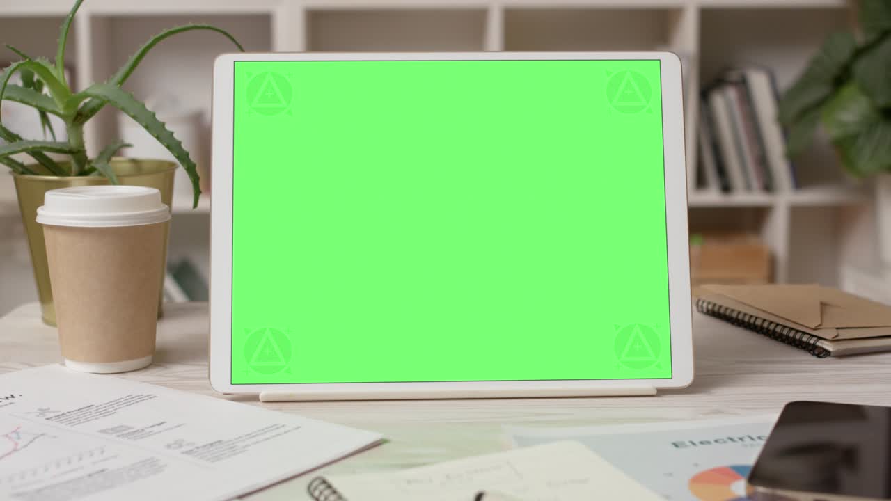 computadora de tableta con pantalla verde en el interior acogedor de la oficina