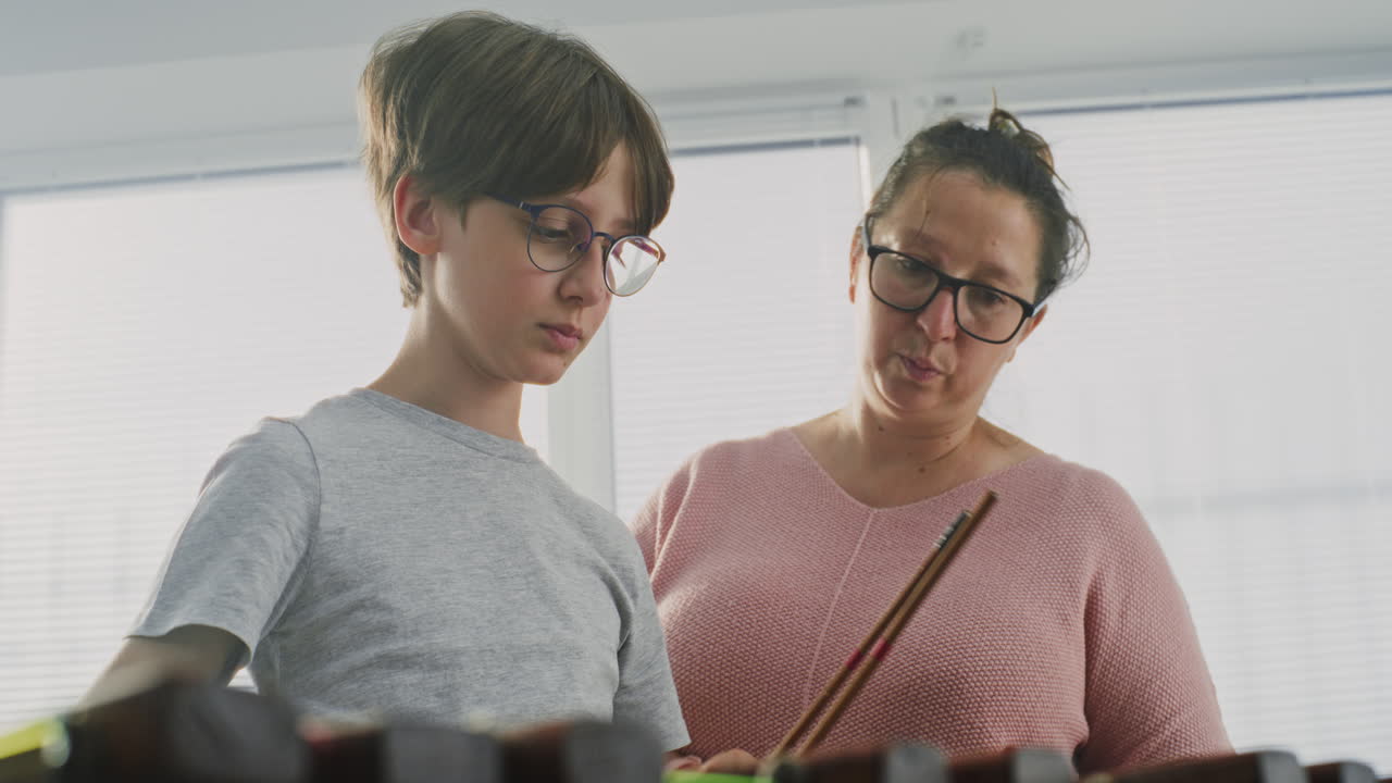 Primary School Boy Practicing Xylophone in Modern Music Class with Teacher