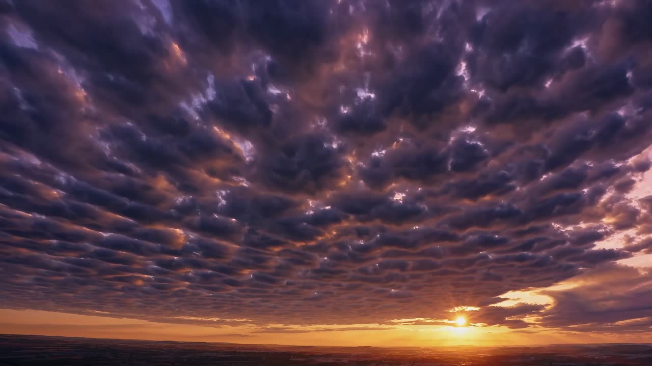 Aerial video captures a dramatic sunset with textured clouds