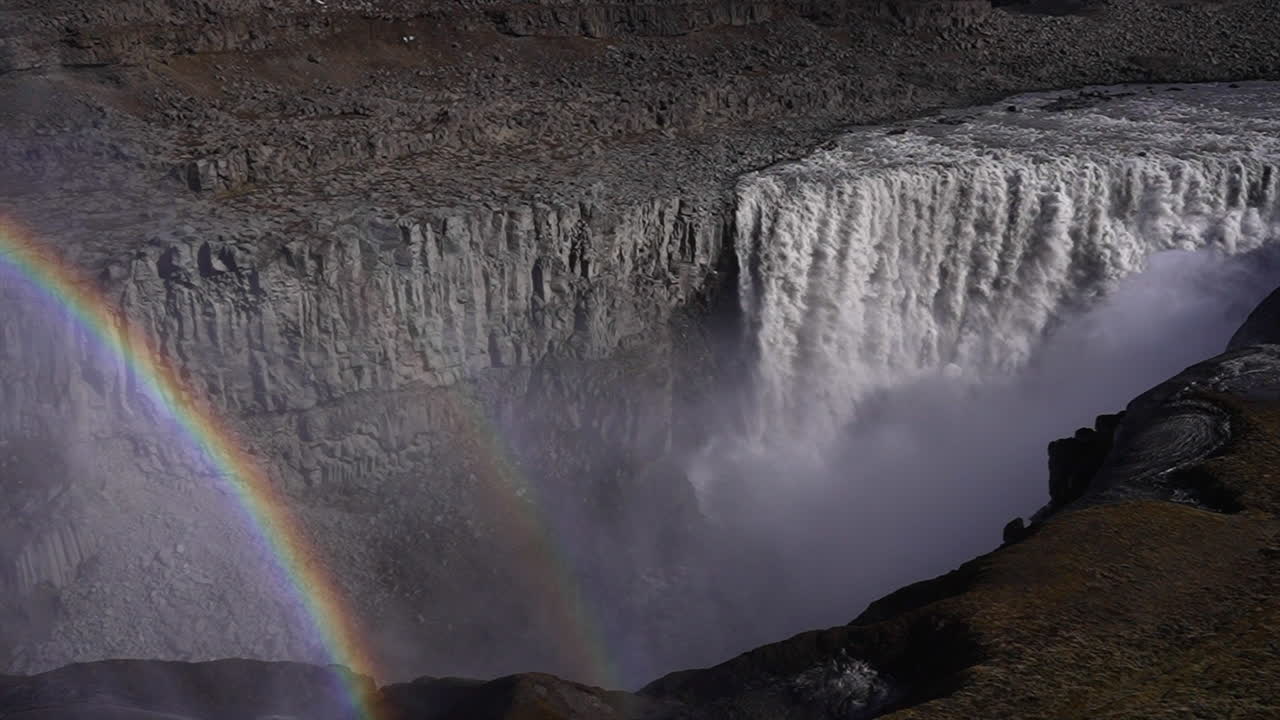 vista de la cima del acantilado de la cascada de dettifoss en islandia con arco iris, cámara lenta