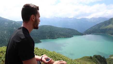 Young-man-during-a-hike-eats-blueberries-for-a-short-break-1