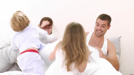 la familia tiene una pelea de almohadas.