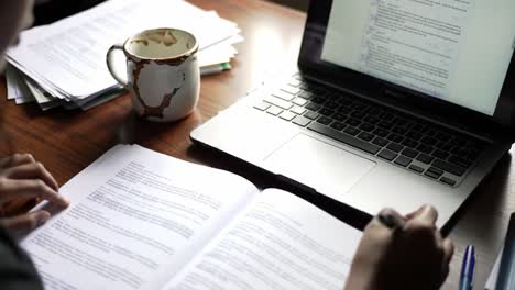 focused study session featuring open laptop, coffee cup, and study materials on a wooden table, highlighting the importance of concentration and learning