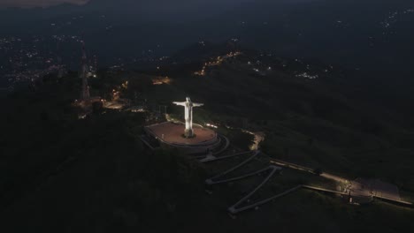 hyperlapse aerial night view of christ the king statue in cali, colombia, filmed by drone
