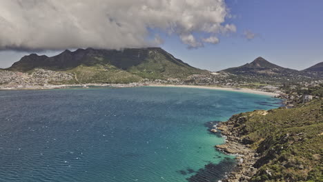 cape town south africa aerial v85 flyover hout bay capturing breathtaking views of coastal shoreline, harbor, sandy beach, townscape and majestic mountains - shot with mavic 3 pro cine - jan 11th 2024