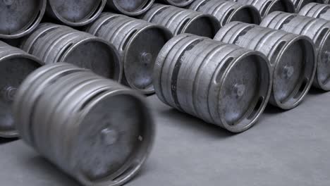 multiple metal beer kegs rolled on the ground sequential. a camera moves back in an endless, seamless loop. soft light illuminates surfaces of cold, steel, worn barrels. warehouse storage work.