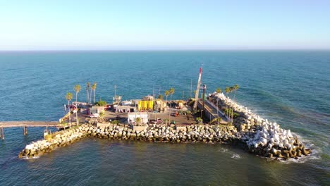 Antenne-über-Einen-Langen-Ölpier,-Der-Sich-Zu-Einer-Kleinen-Insel-Vor-Der-Küste-Von-Muschelschwärmen-Erstreckt-Rincon-Beach-Santa-Barbara-Kalifornien-2