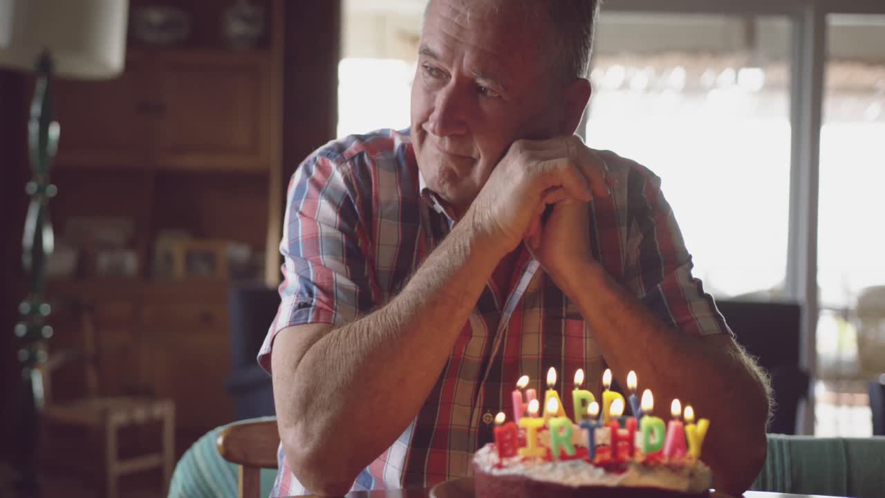 Uomo anziano con una torta di compleanno a casa