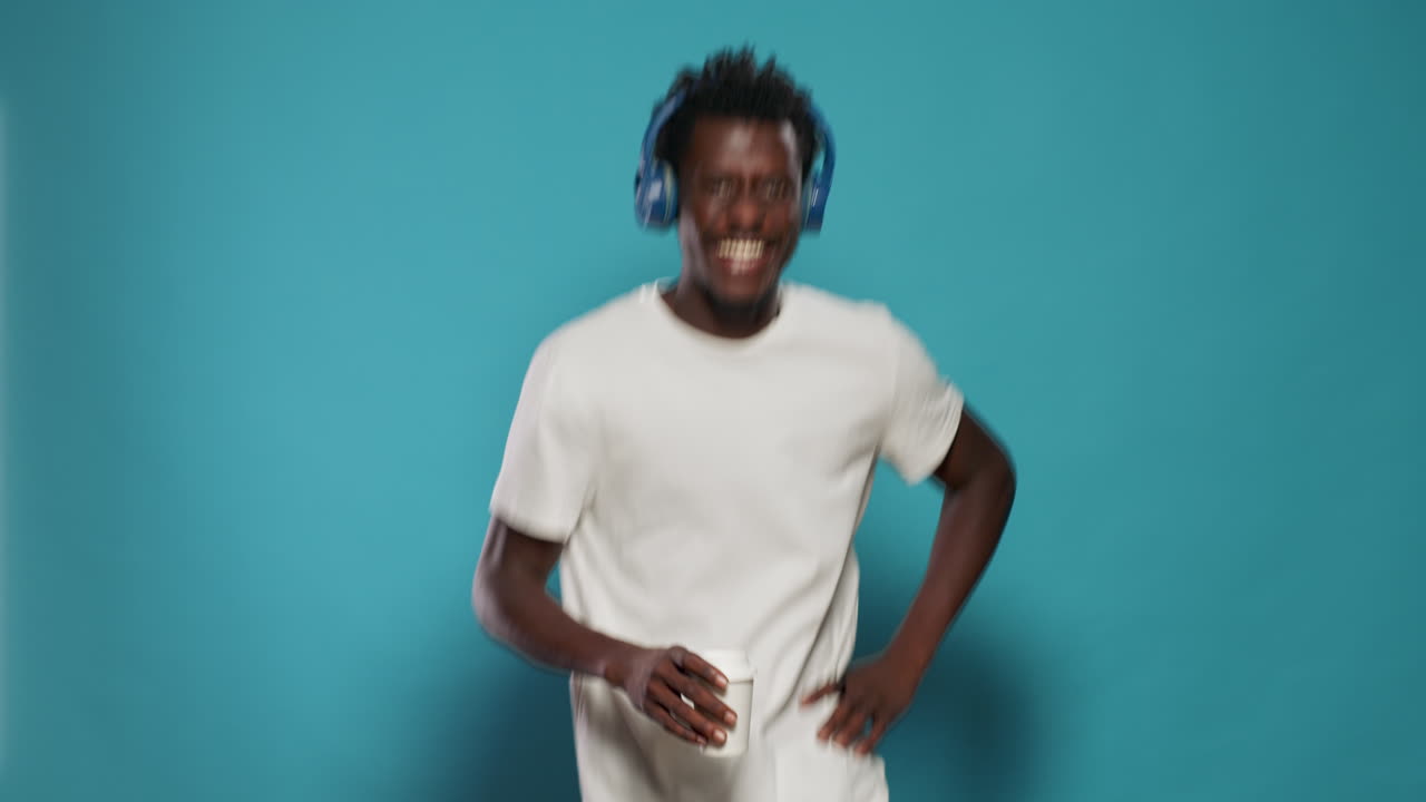 Portrait of man with headphones jumping and dancing to song