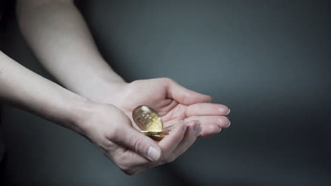 open palms catching falling cryptocurrency coins, black background