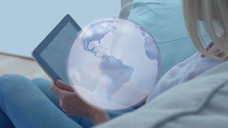 animation of globe over caucasian businesswoman using tablet