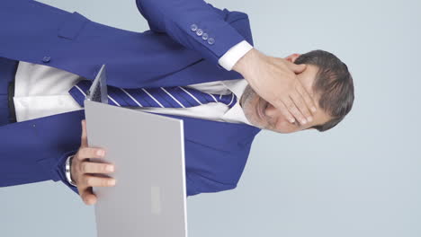 Vertical-video-of-Businessman-looking-at-laptop-getting-frustrated.-Sad-and-helpless.