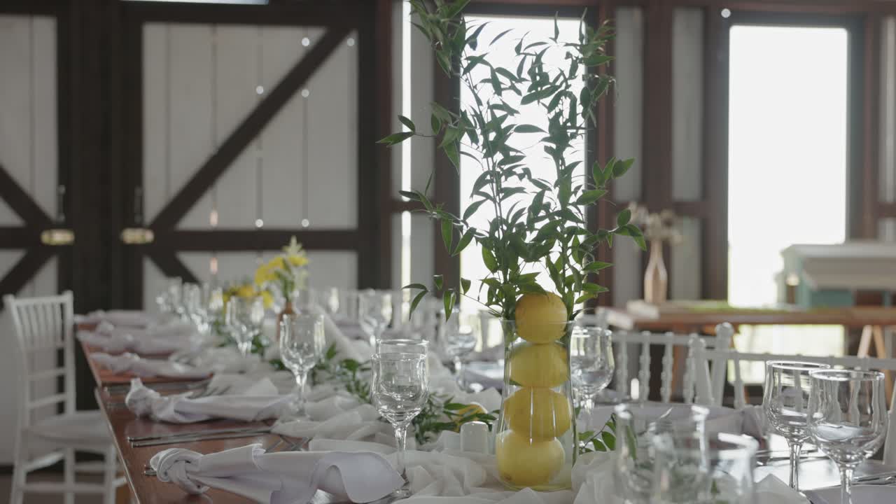 Centerpiece Vase Filled With Lemons And Greenery On Elegant Dining Table At Wedding Reception. closeup, wide shot