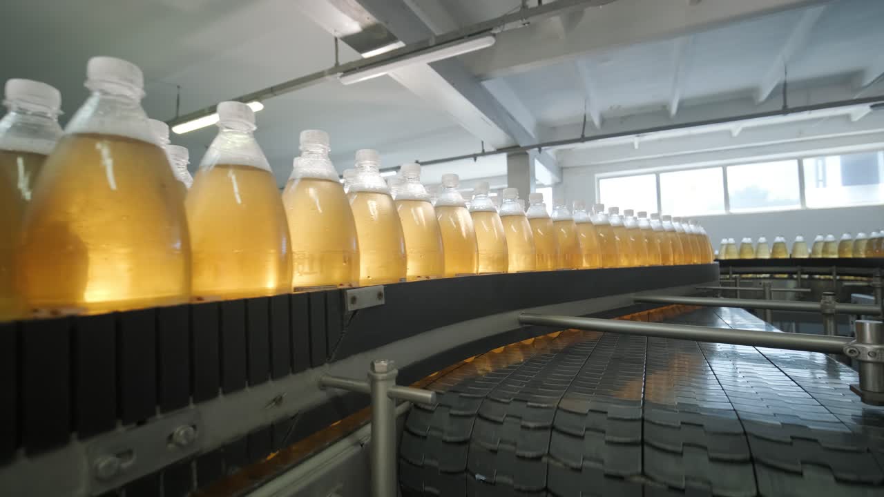 cinta transportadora con botellas para jugo o agua en una planta moderna de bebidas. producción moderna de agua dulce soda