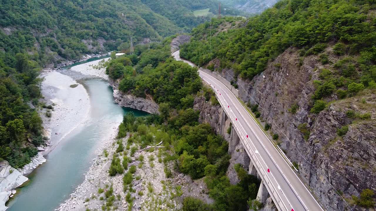 지나가는 자동차, 강, 자연과 함께 도로 위를 촬영한 시네마틱 드론