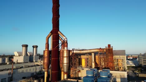 Slow-pan-of-Power-Station-Guernsey-showing-chimneys-and-equipment-with-golden-sun