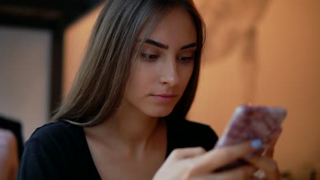 Vista-De-Cerca-De-Una-Joven-Atractiva-Con-Maquillaje-Natural-Usando-Su-Teléfono-Móvil-En-La-Toma-De-Café.-Uso-De-Dispositivos-Modernos