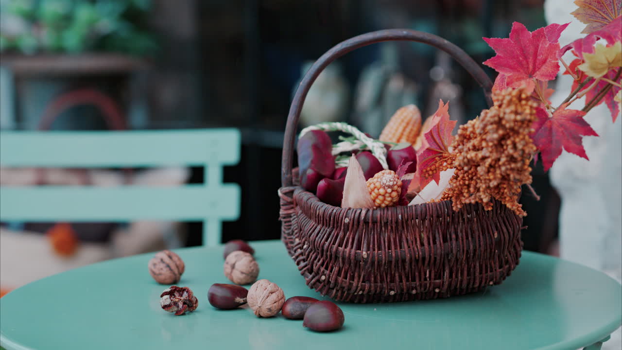 Un cesto pieno di decorazioni a tema autunnale su un tavolo in terrazza
