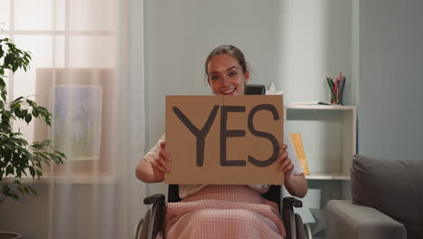 paralyzed woman shows poster with inscription yes smiling