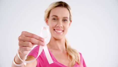 Smiling-woman-showing-breast-cancer-awareness-ribbon