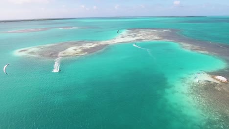 Hombre-Aventurero-Kitesurf-Hermosa-Cámara-Frontal-Del-Mar-Caribe-En-Palafito,-Toma-Aérea-Los-Roques