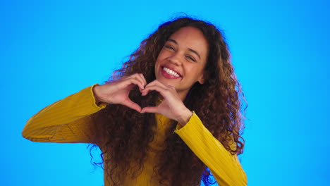 Face,-smile-and-woman-with-heart-hands-in-studio