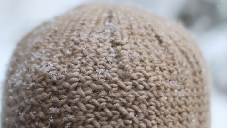 close-up of a knitted hat covered in snow