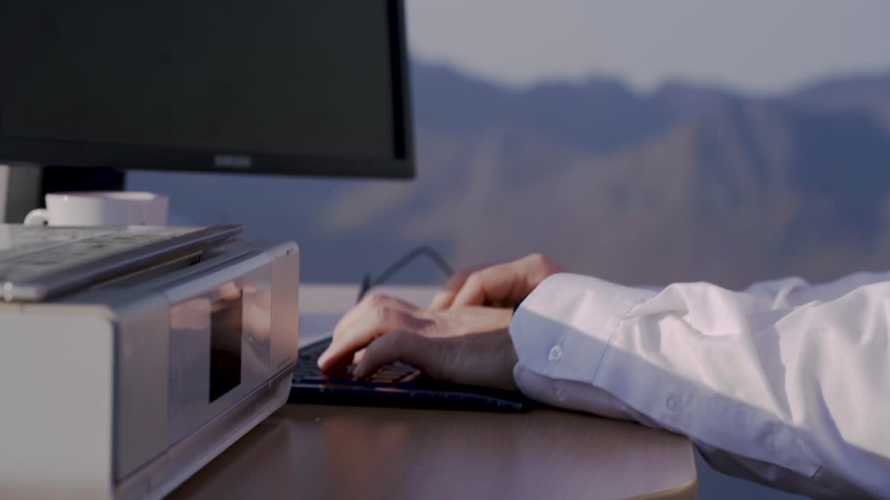 Man Working on Computer with Mountain View