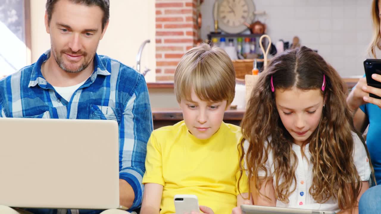 familia usando dispositivos en el sofá