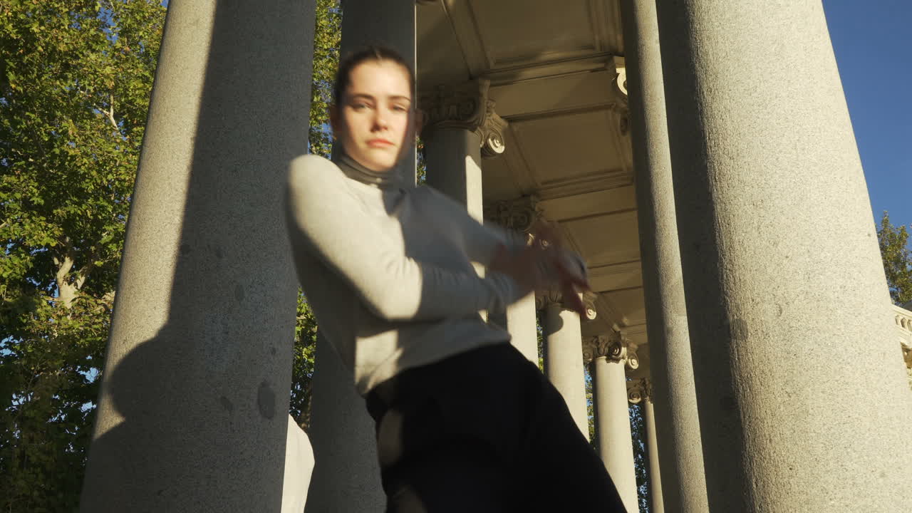 young group dancing choreography between tall columns