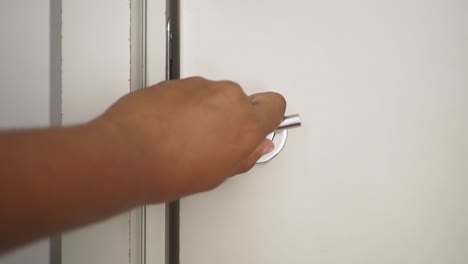 a hand opening a door