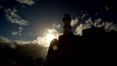 lighthouse on the wall of the fortress of famagusta and the evening sun near closed ghost town varosha in north cyprus