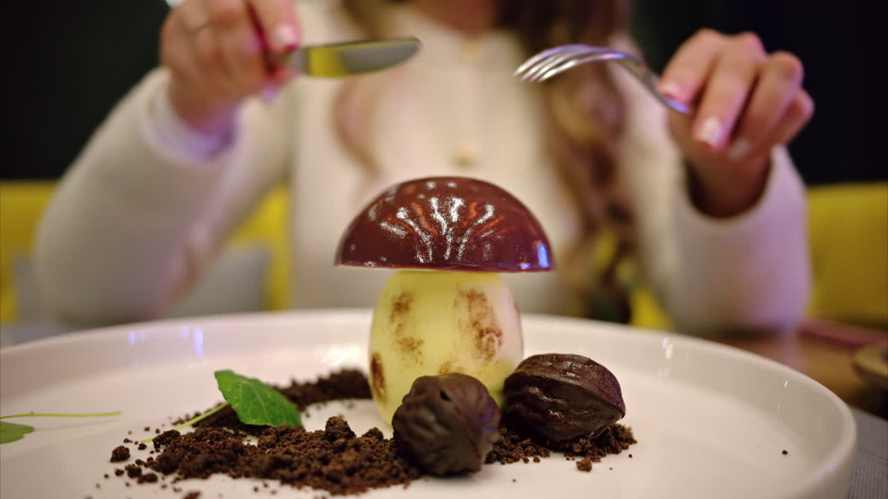Woman cutting up chocolate mushroom desert at a restaurant