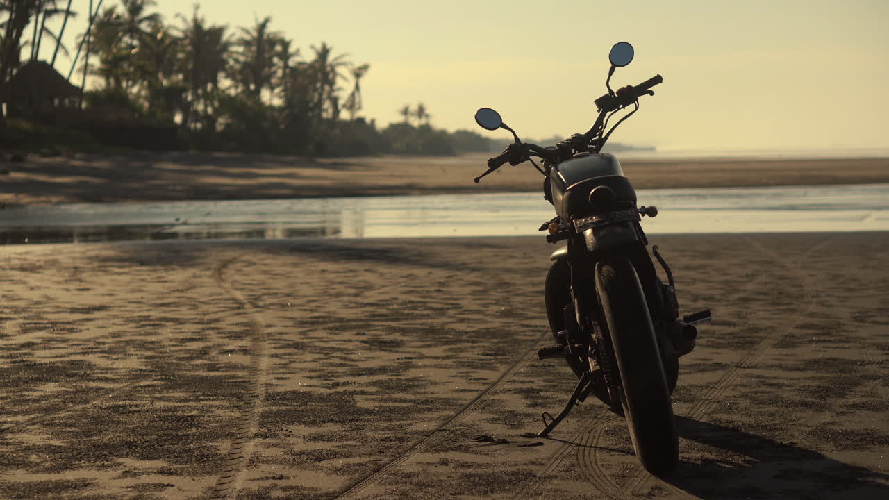 motocicleta antigua en una playa de amanecer