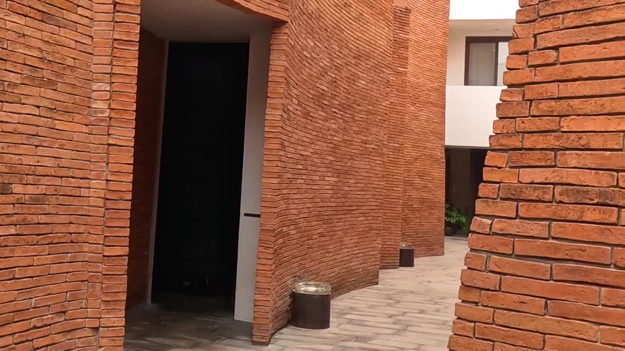 Explore a narrow brick corridor featuring modern architectural details and a unique pathway design.