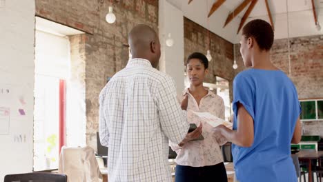 Happy-african-american-colleagues-using-tablet-and-discussing-work-in-office,-slow-motion