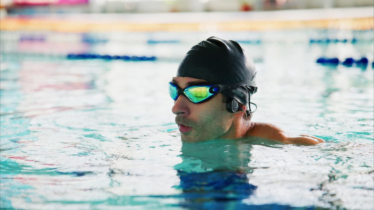 Focused Swimmer Preparing for the Race: An Intense Athlete in Swim Gear, Captured in the Pool's Glimmering Water During Training Sessions