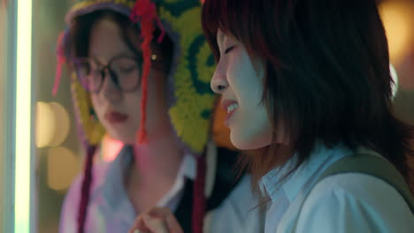 two friends look intently and then sadden at night time carnival fair