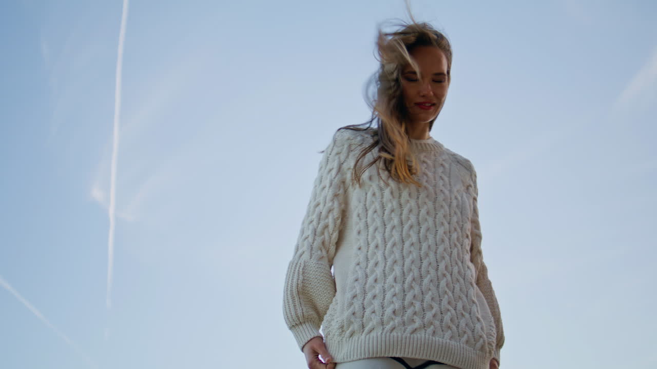 Woman standing morning sky looking camera. Carefree lady with windblown hair